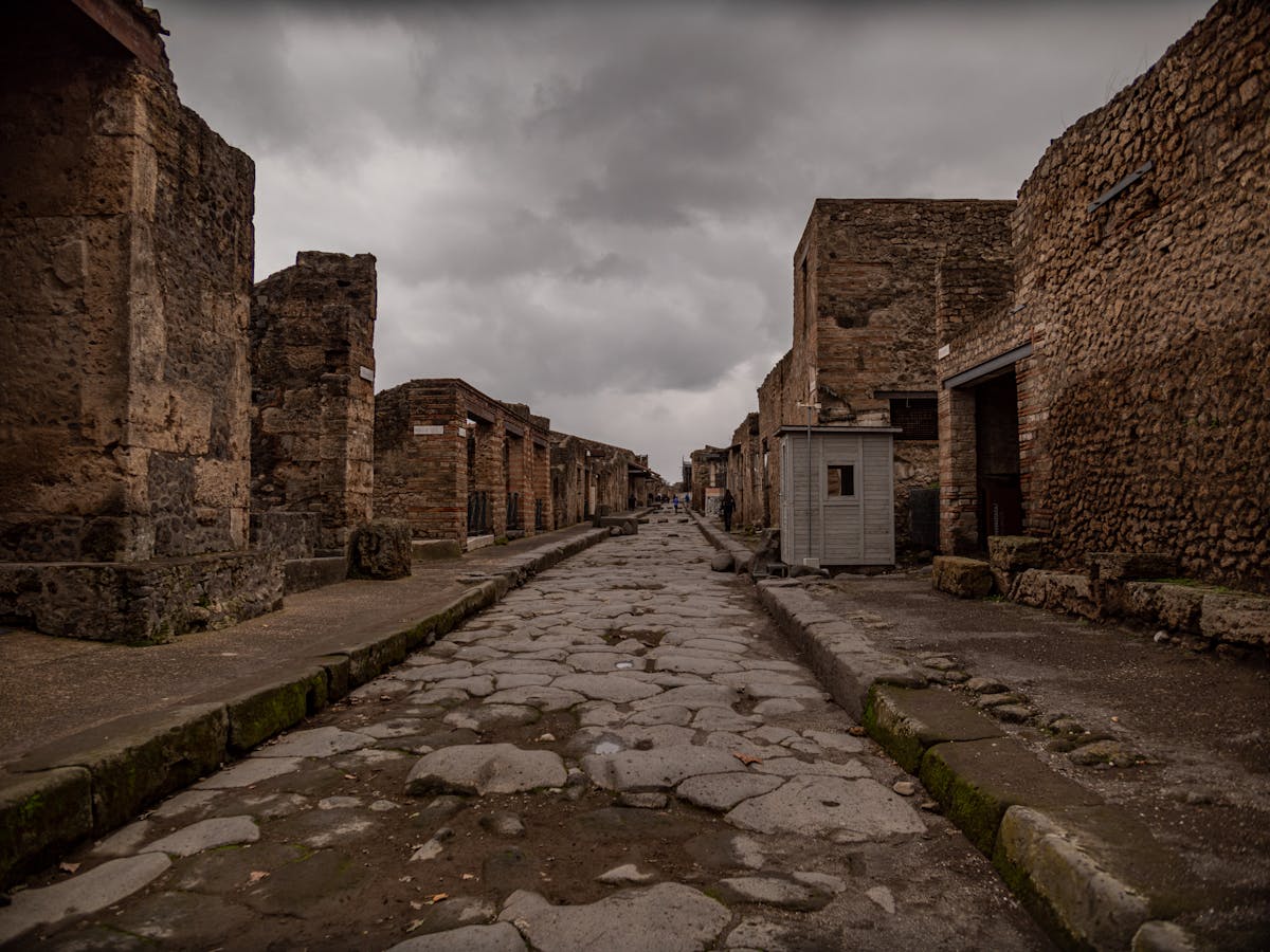 A deserted ancient street in Pompeii Italy with stone buildings on both sides