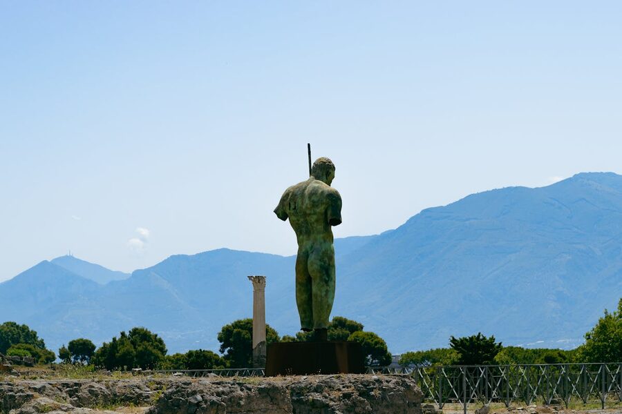 Bronze statue in Pompeii with Mount Vesuvius in the background