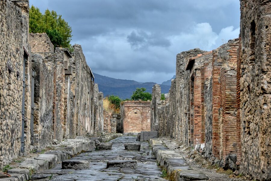 Ancient ruins of Pompeii with mountain views under cloudy sky