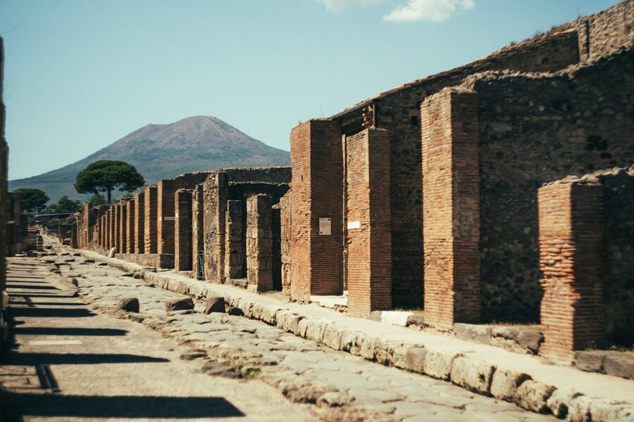 Ancient streets of Pompeii with Mount Vesuvius visible in the distance