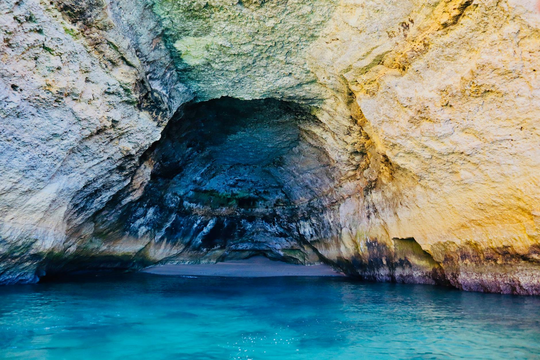 Turquoise water sparkling inside a sea cave along the Algarve coast in Portugal
