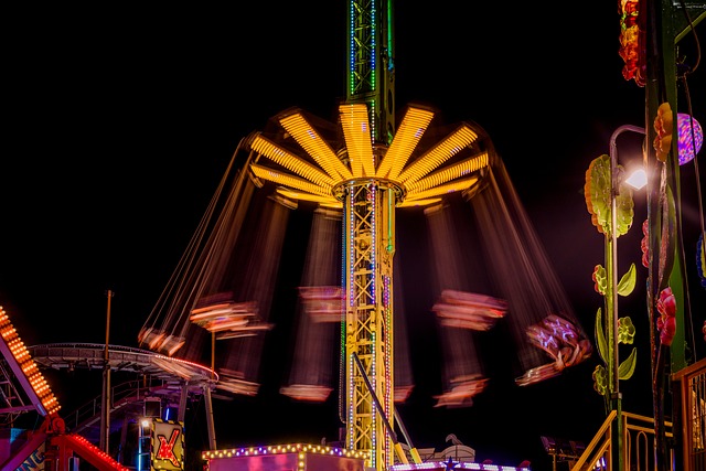 Theme park ride with neon lights illuminated in the evening