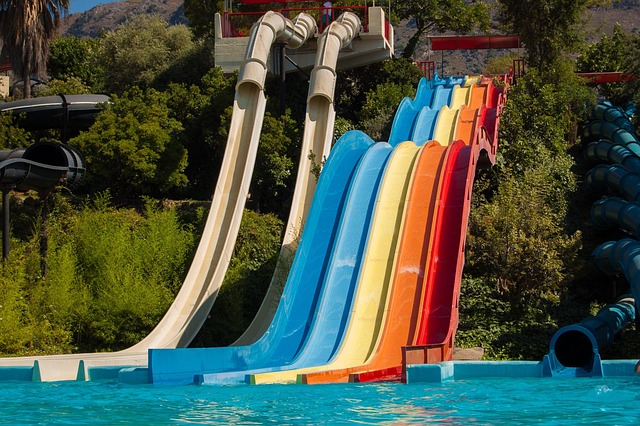 Water park with colorful slides and pool on sunny day