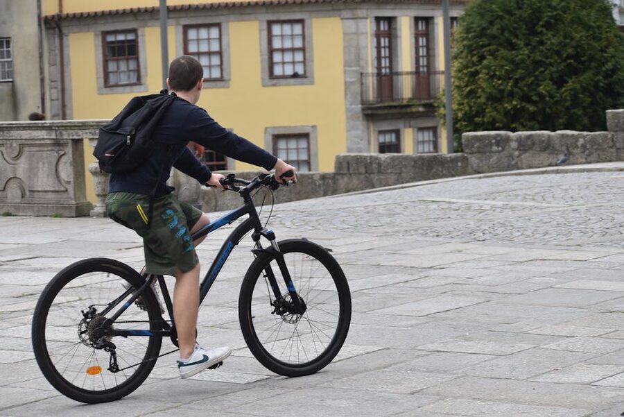 Cyclist riding through Porto cobblestone streets