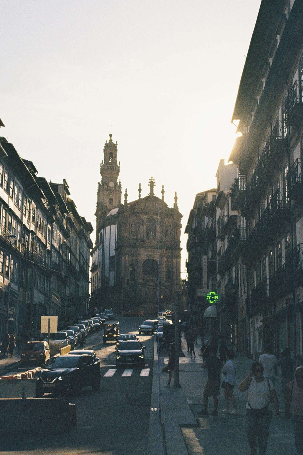 Clerigos Church and Tower in Porto at sunset with vehicles on the street