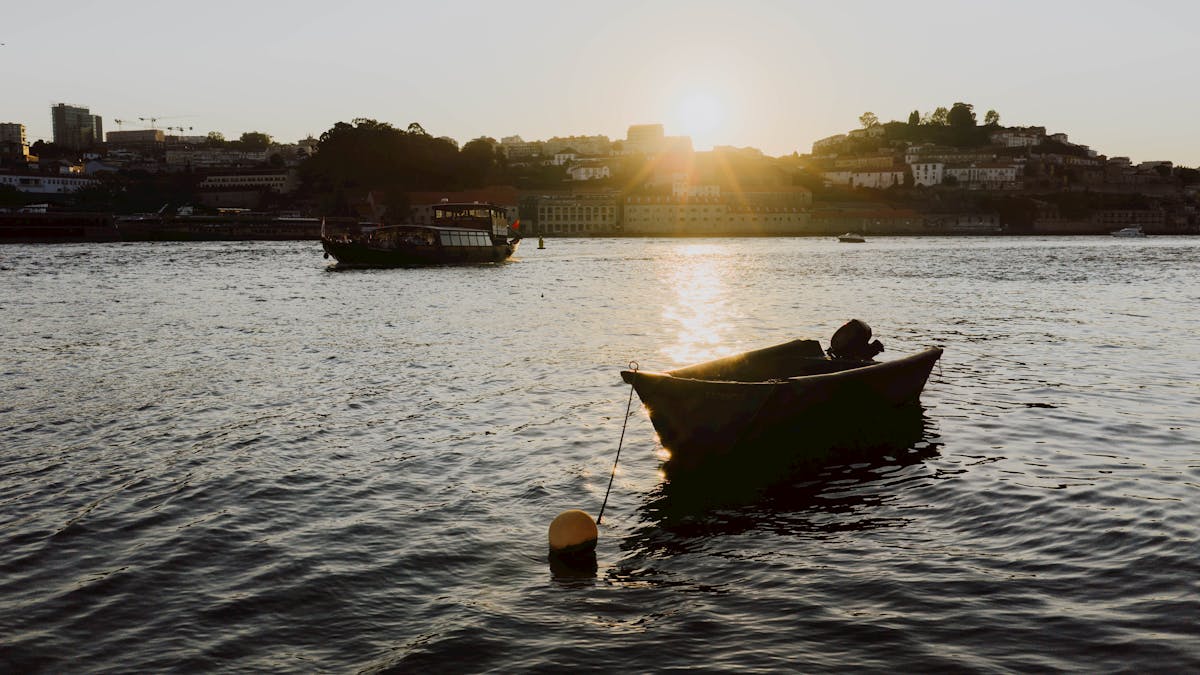 Golden sunset over the Douro River in Porto with silhouettes of boats