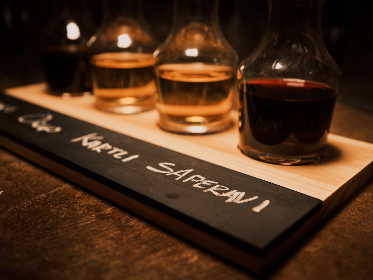 Wine flight with small carafes on a chalkboard labeled tray