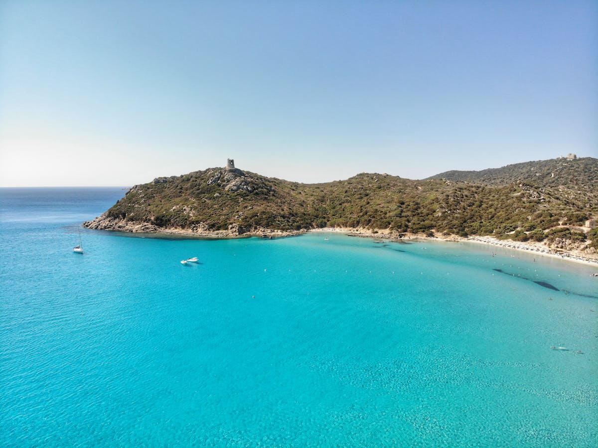 Aerial view of Porto Giunco Tower and turquoise waters in Villasimius Sardinia
