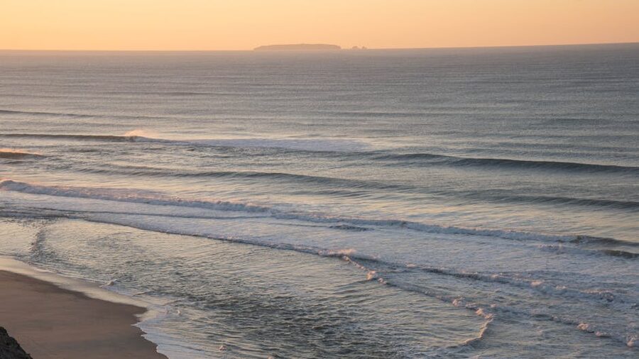 Sunrise at Nazare beach with serene ocean waves