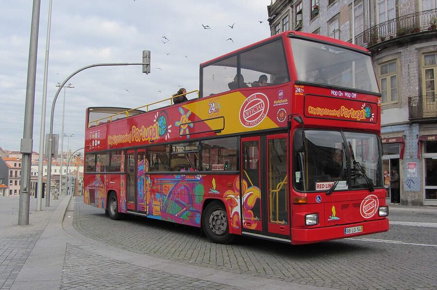 A red double-decker sightseeing bus in central Porto