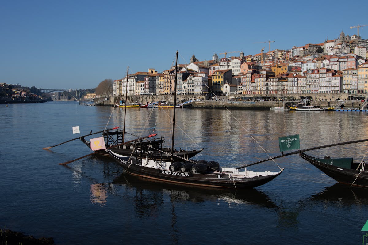Traditional Portuguese boats along the Porto waterfront with colorful buildings