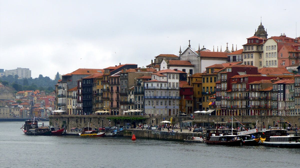 Porto cityscape with colorful buildings and boats along the Douro River waterfront