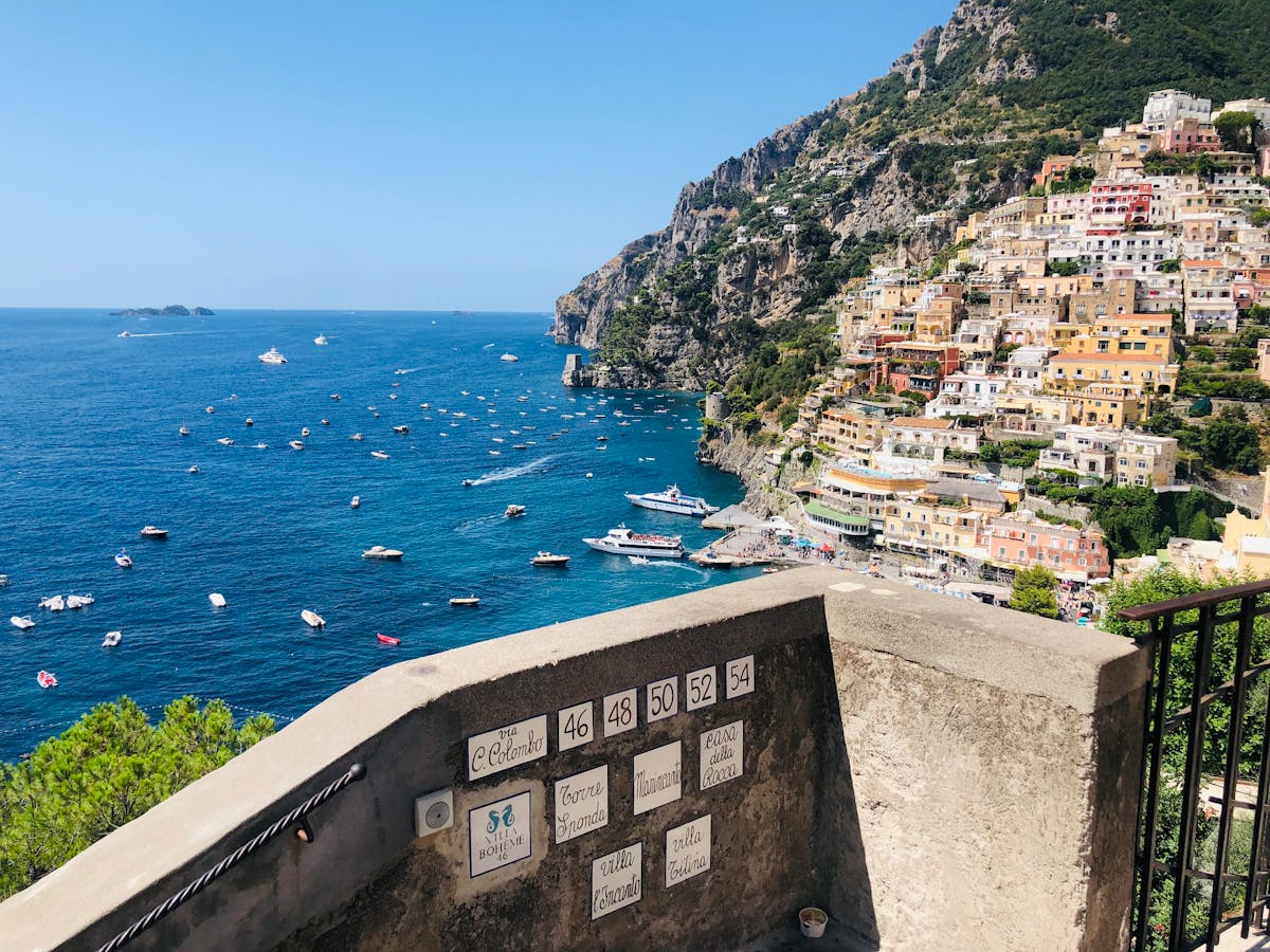 Balcony view overlooking Positano town and boats at sea
