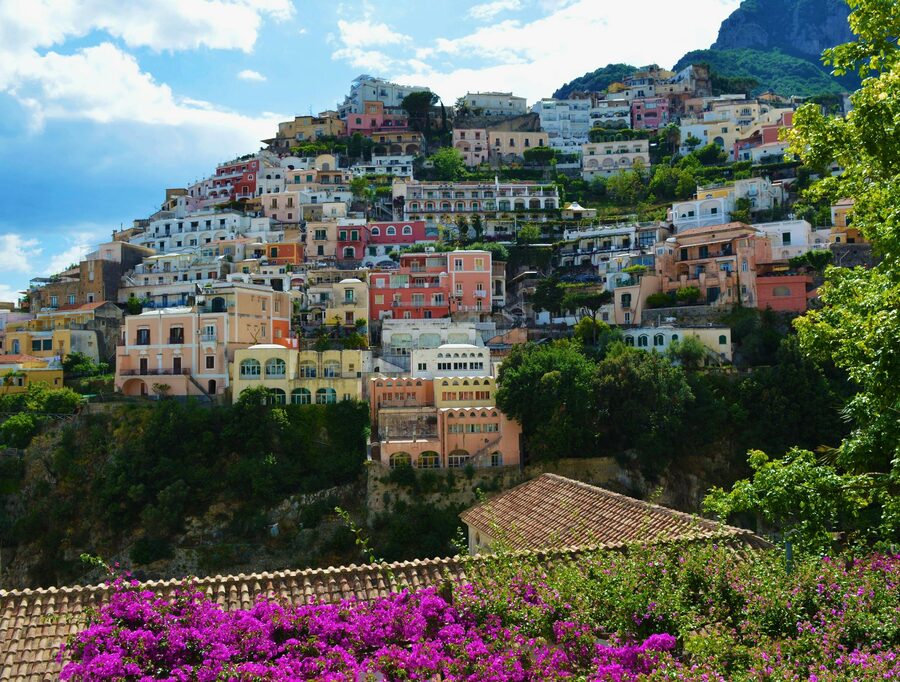Panoramic view of Positano with colorful buildings cascading down the hillside toward the Amalfi Coast sea