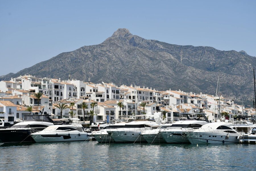 Luxury yachts docked at Puerto Banus with mountain backdrop in Marbella