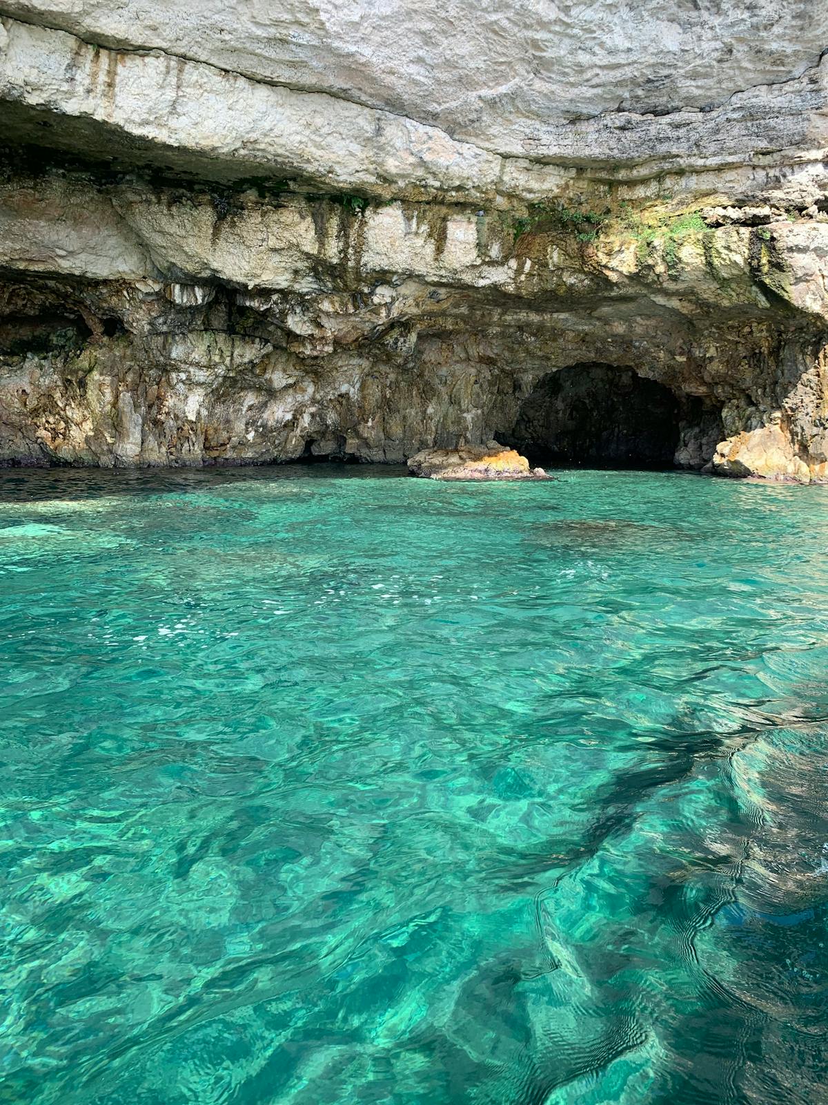 Crystal clear turquoise water inside a limestone sea cave in Puglia Italy