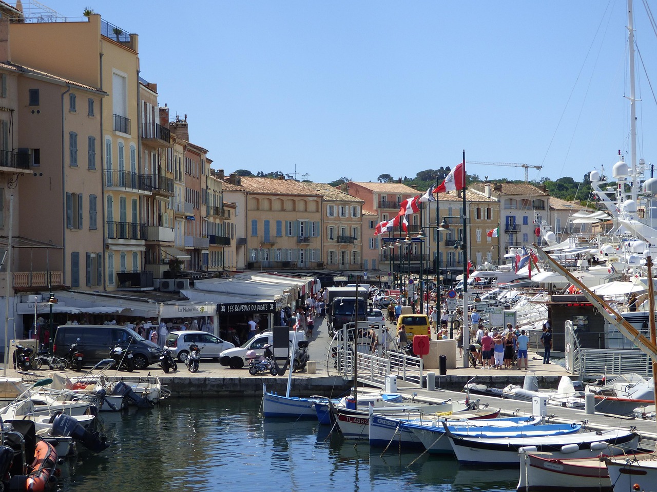 Fishing boats and yachts in Saint-Tropez port with orange and yellow Provencal buildings
