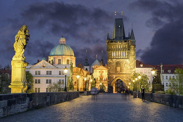 Charles Bridge spanning the Vltava River at dusk with Prague Castle visible