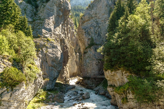 Deep narrow glacier canyon gorge with blue-green water near Grindelwald