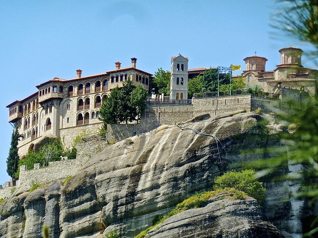 Meteora monastery buildings and dramatic rock formations at golden sunset in Greece