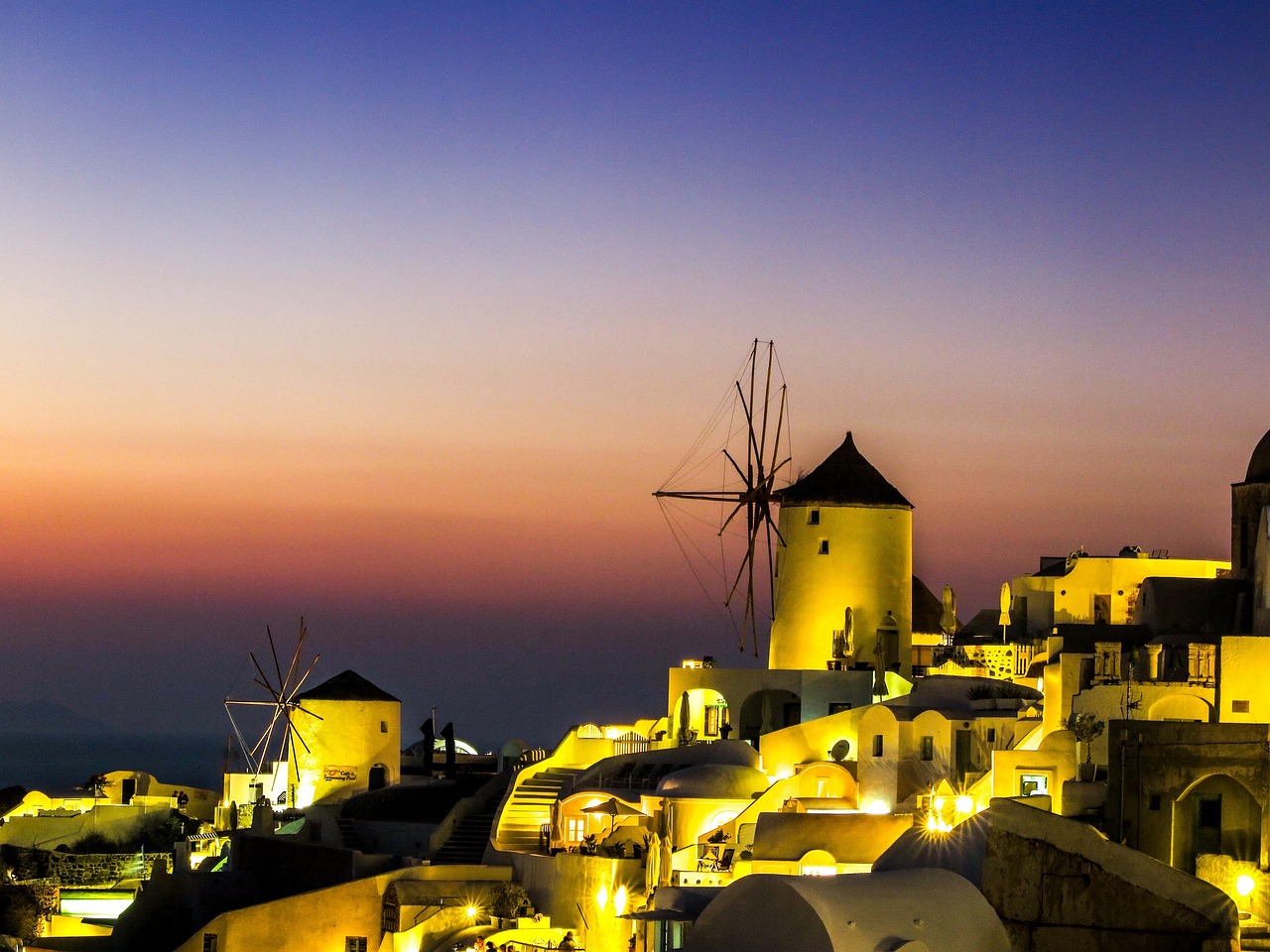 Oia windmill against golden sunset sky in Santorini
