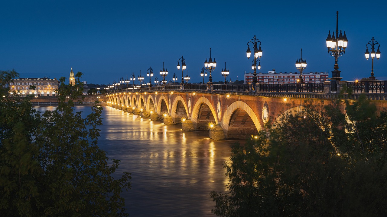 Night view of bridge and Garonne River in Bordeaux with city lights reflecting on water