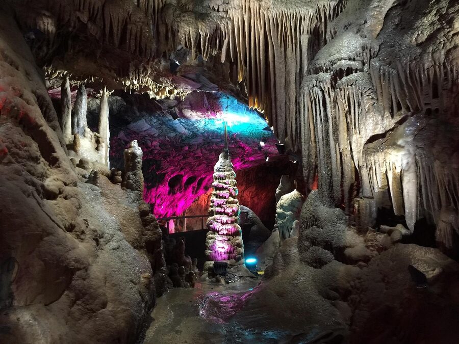 Stalactite cave interior illuminated with warm amber lighting