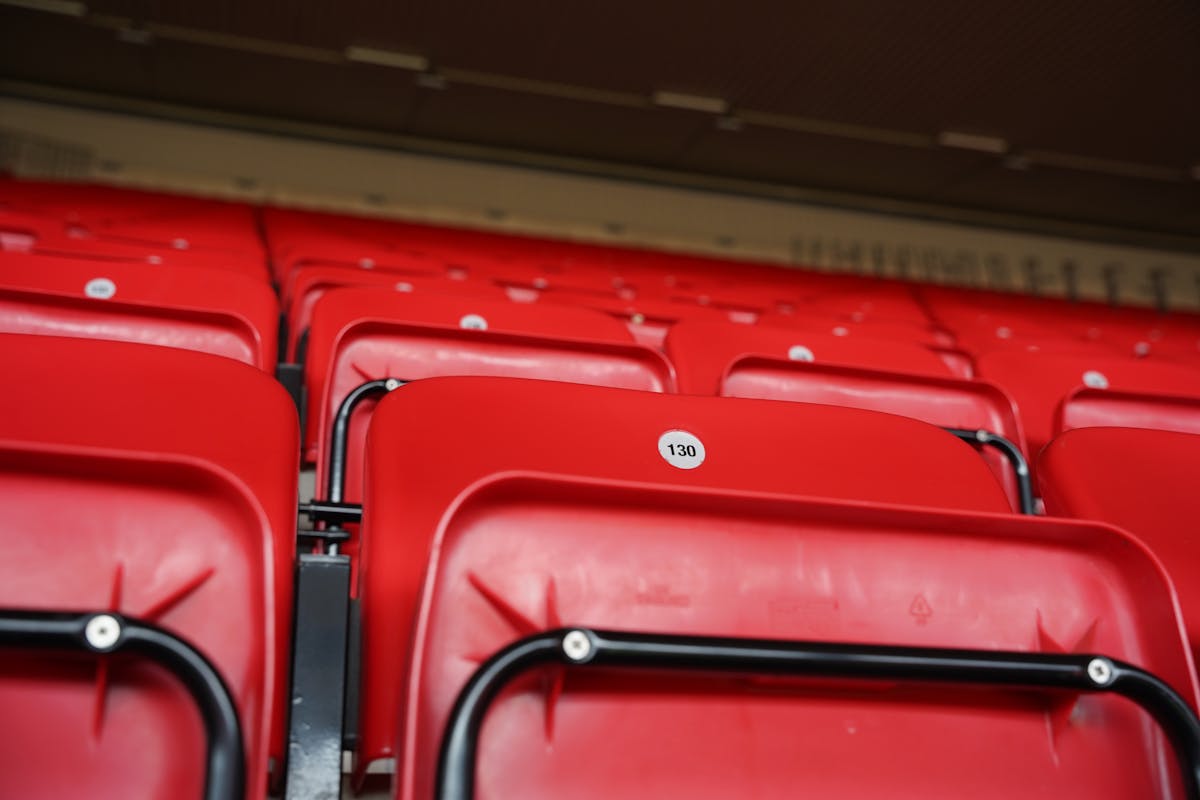 Close-up of numbered red stadium seats at Anfield