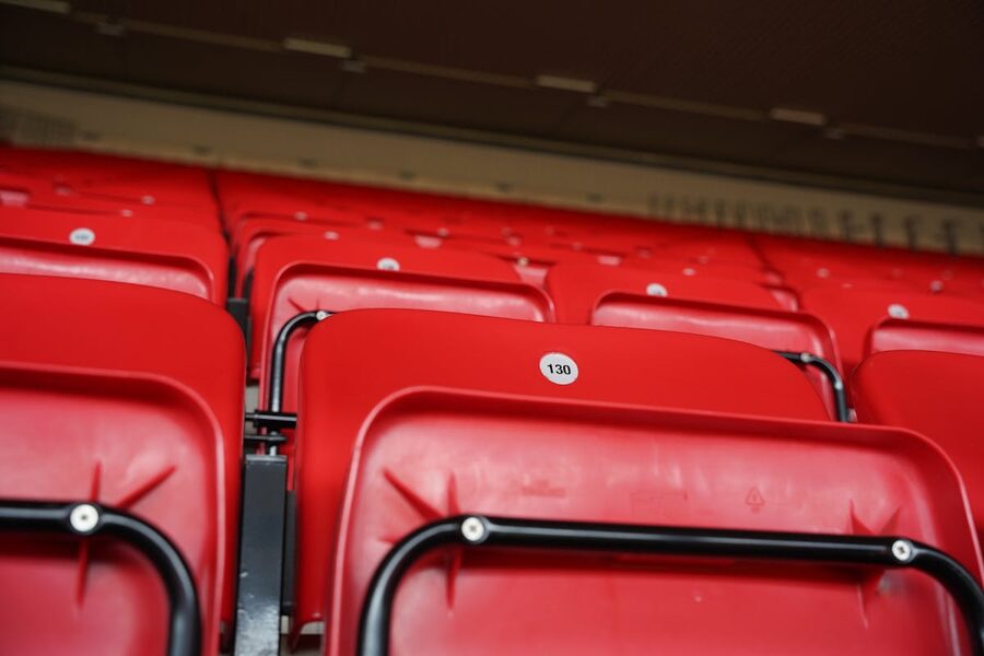 Close-up of numbered red seats in a football stadium