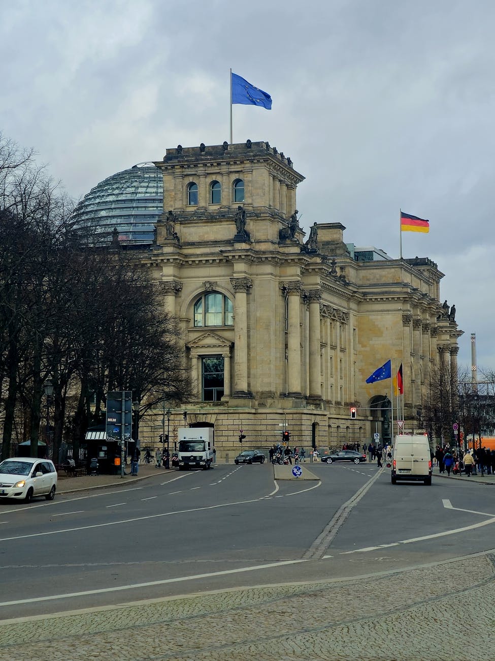 The Reichstag building in Berlin with German and EU flags flying from the roof