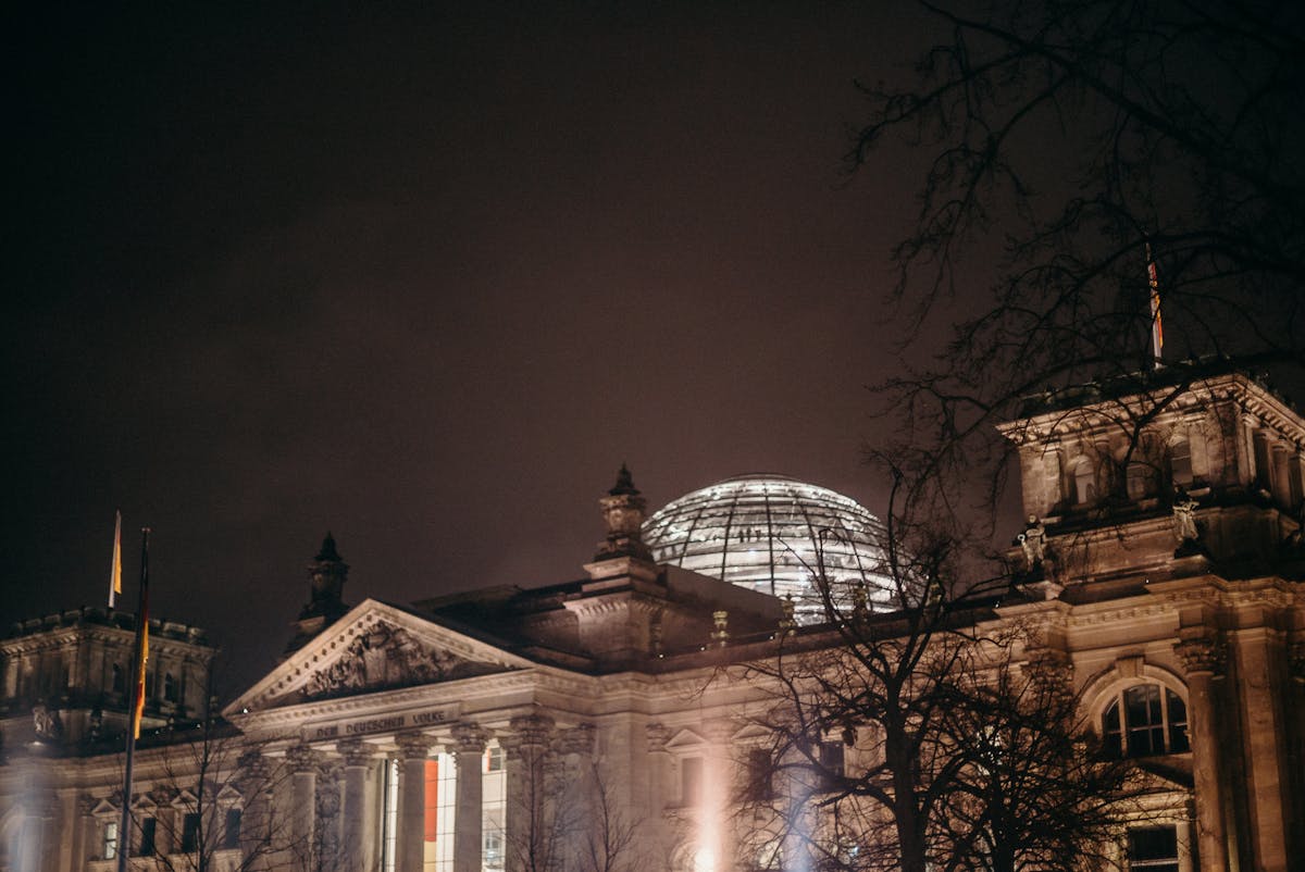 The Reichstag building illuminated at night with its glowing glass dome