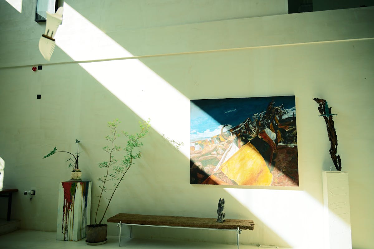 Spacious art gallery featuring abstract paintings and sculptures with natural lighting