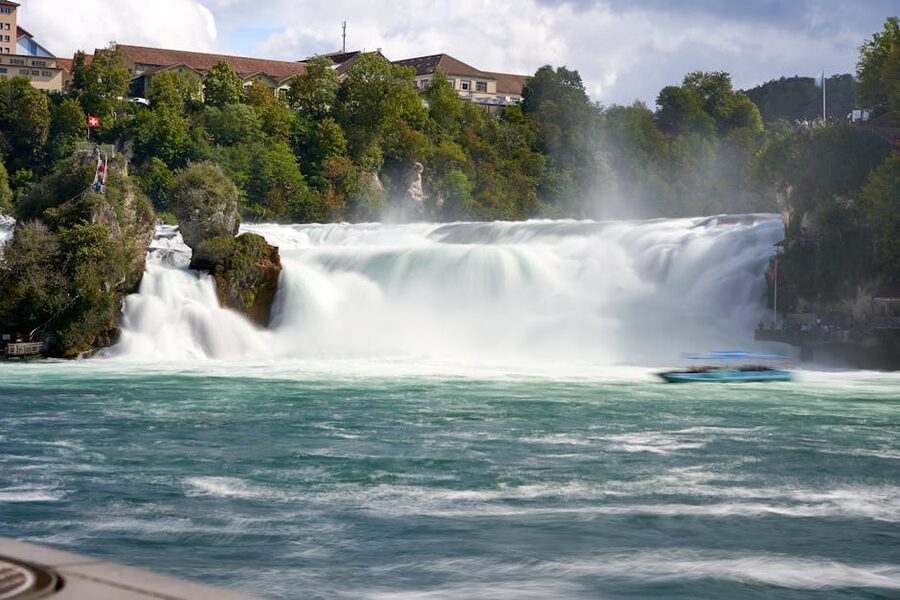 Powerful Rheinfall waterfall surrounded by greenery