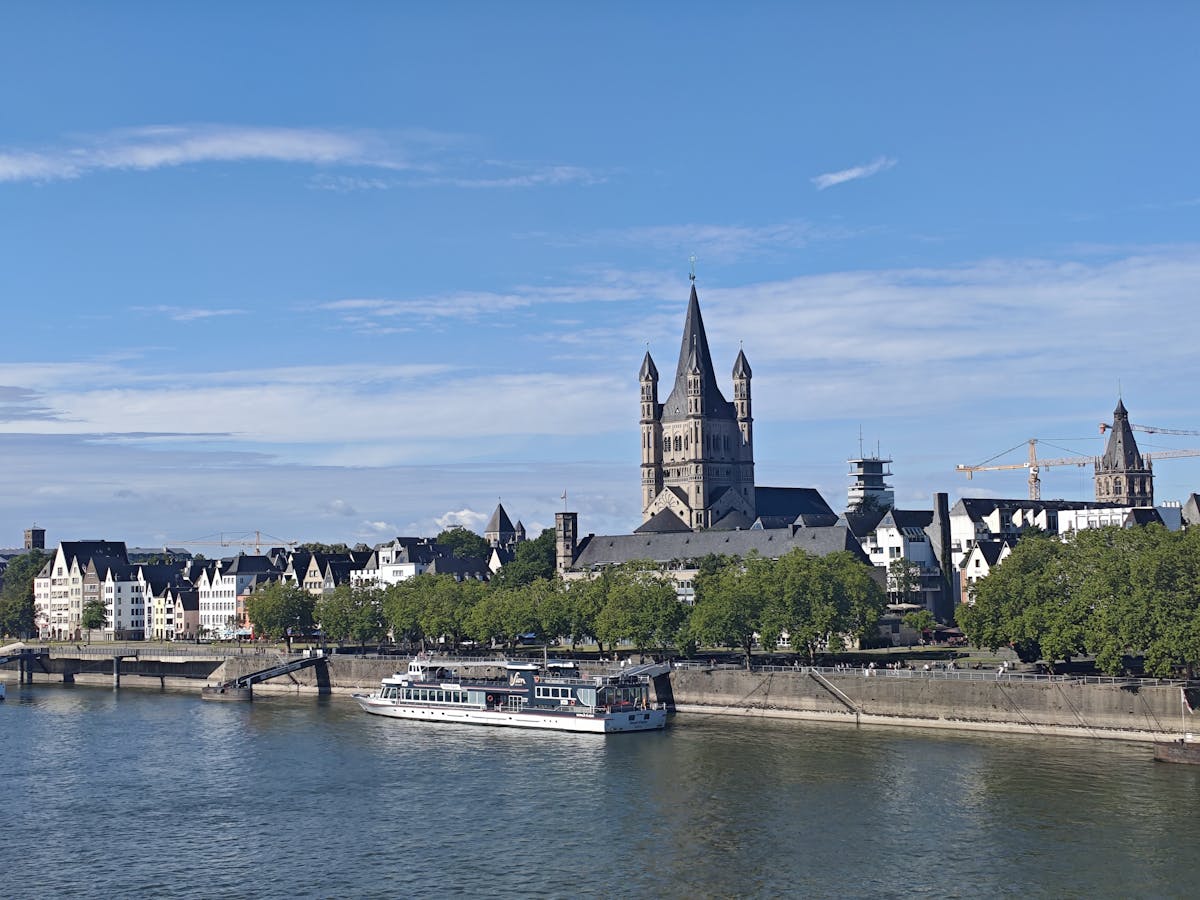 Cologne riverside with Great St. Martin Church and ship on the Rhine River