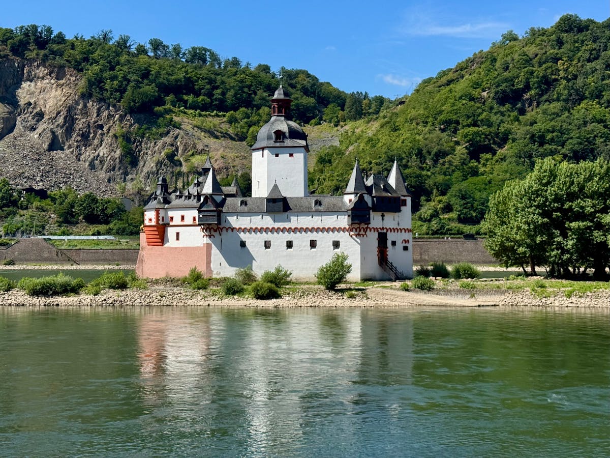 Pfalzgrafenstein Castle on the Rhine River surrounded by green hills