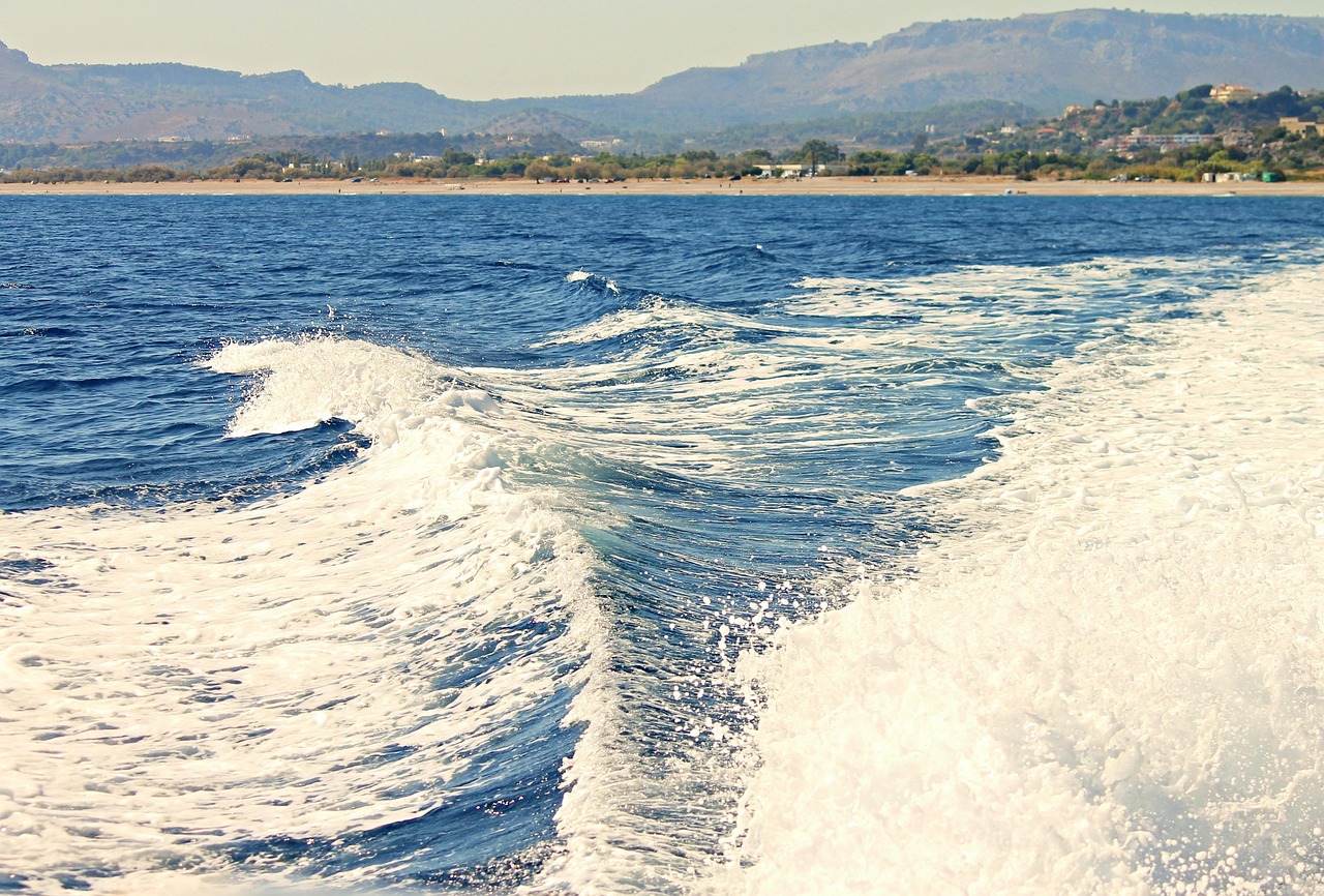 Speedboat with white wake along coast of Rhodes