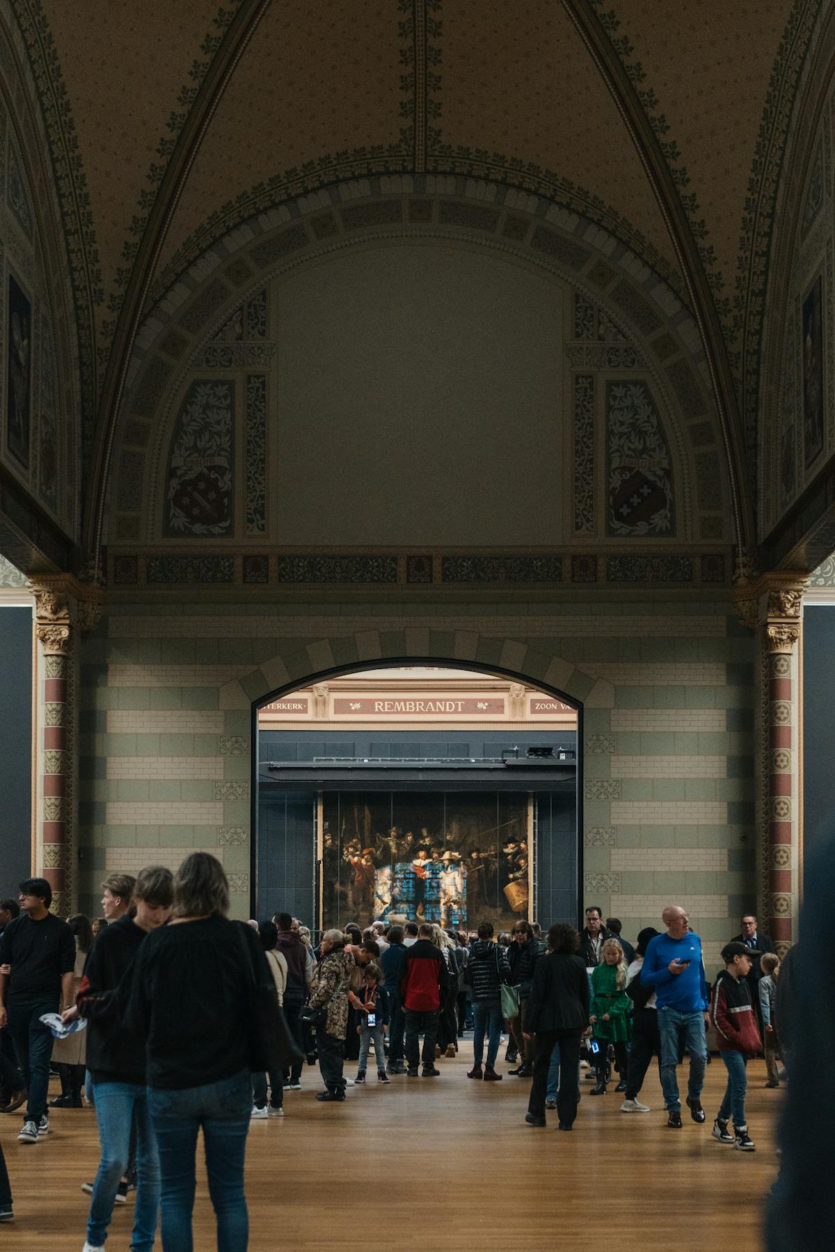 Visitors exploring the grand hall of the Rijksmuseum with its soaring architecture