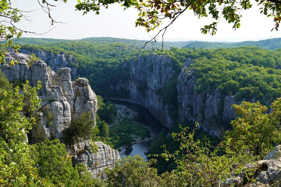 River flowing through a gorge with cliff walls and surrounding greenery