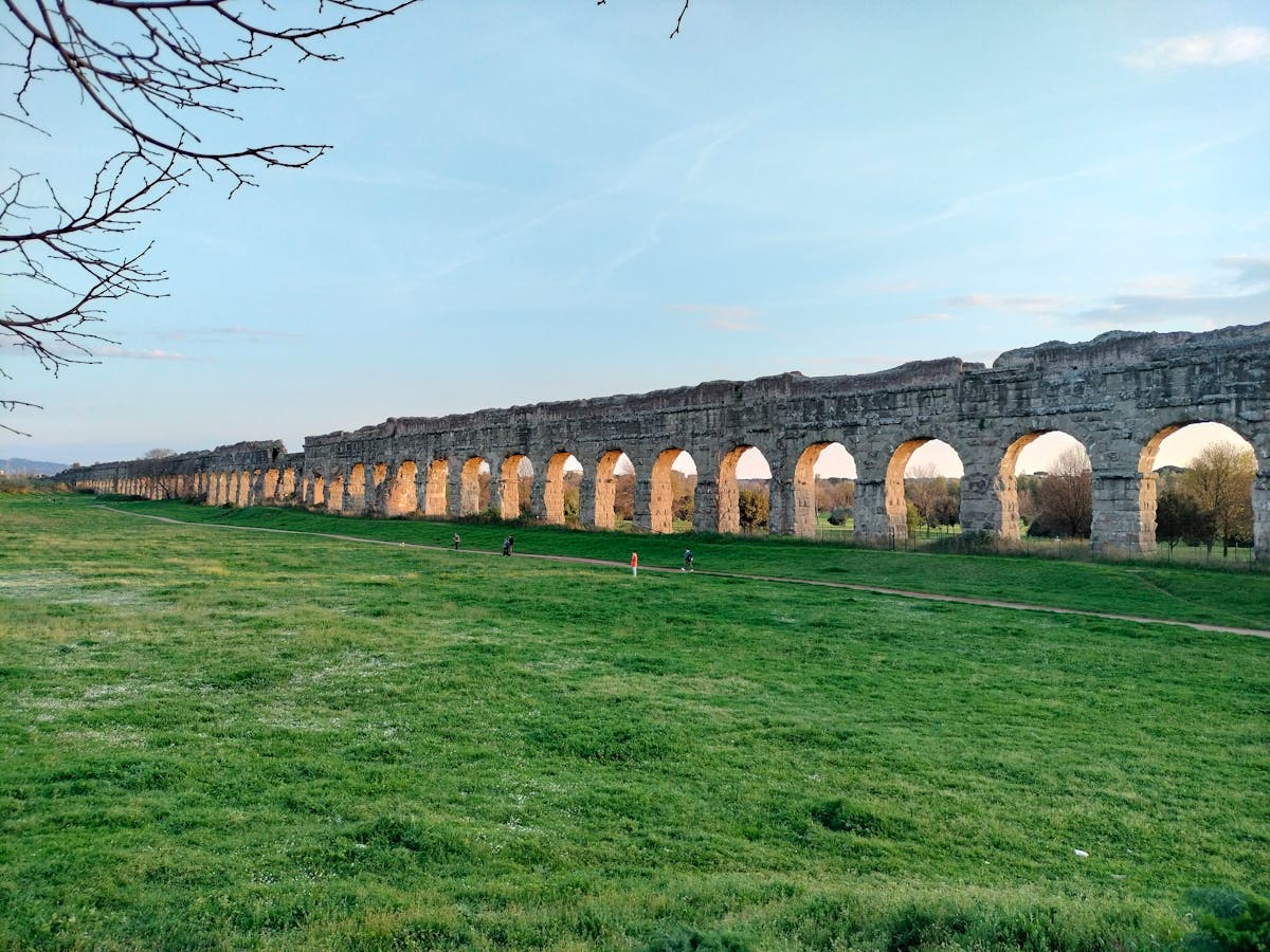 Ancient Roman aqueduct ruins in a park near Rome at sunset