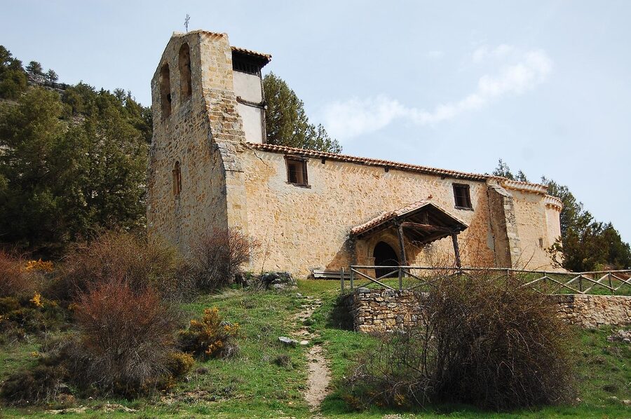 Romanesque church with stone bell tower in mountain setting