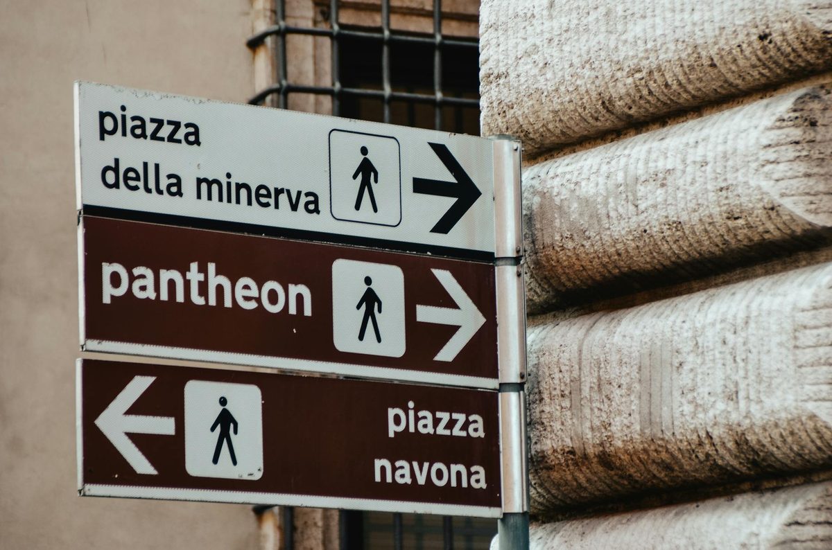 Direction signs pointing to the Pantheon and other landmarks in Rome
