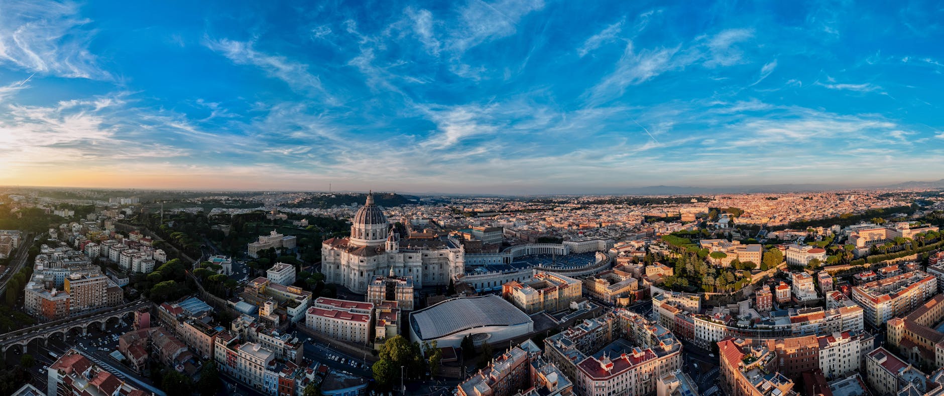 Panoramic view of Rome skyline with St Peters Basilica dome at sunset