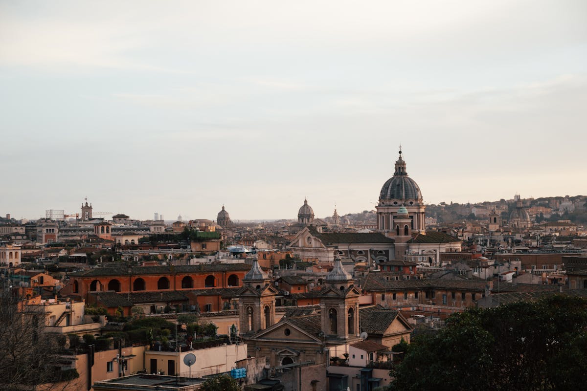 Rome skyline at dusk featuring historic church domes and rooftops
