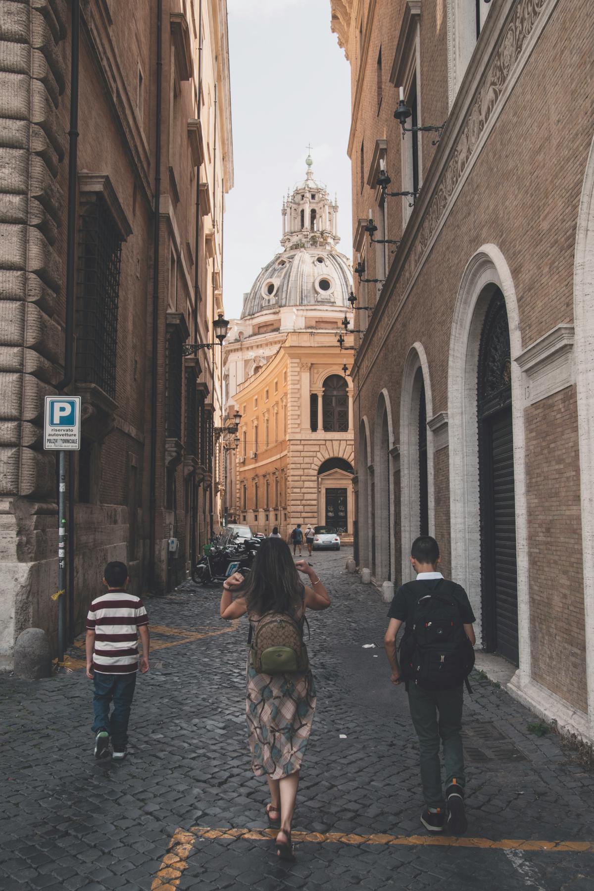 People walking through historic cobblestone streets in Rome