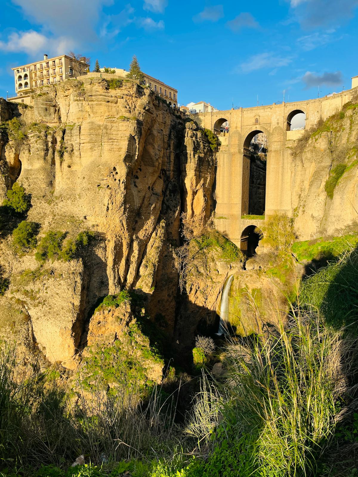 Ronda Puente Nuevo bridge framed against dramatic cliff face and atmospheric sky