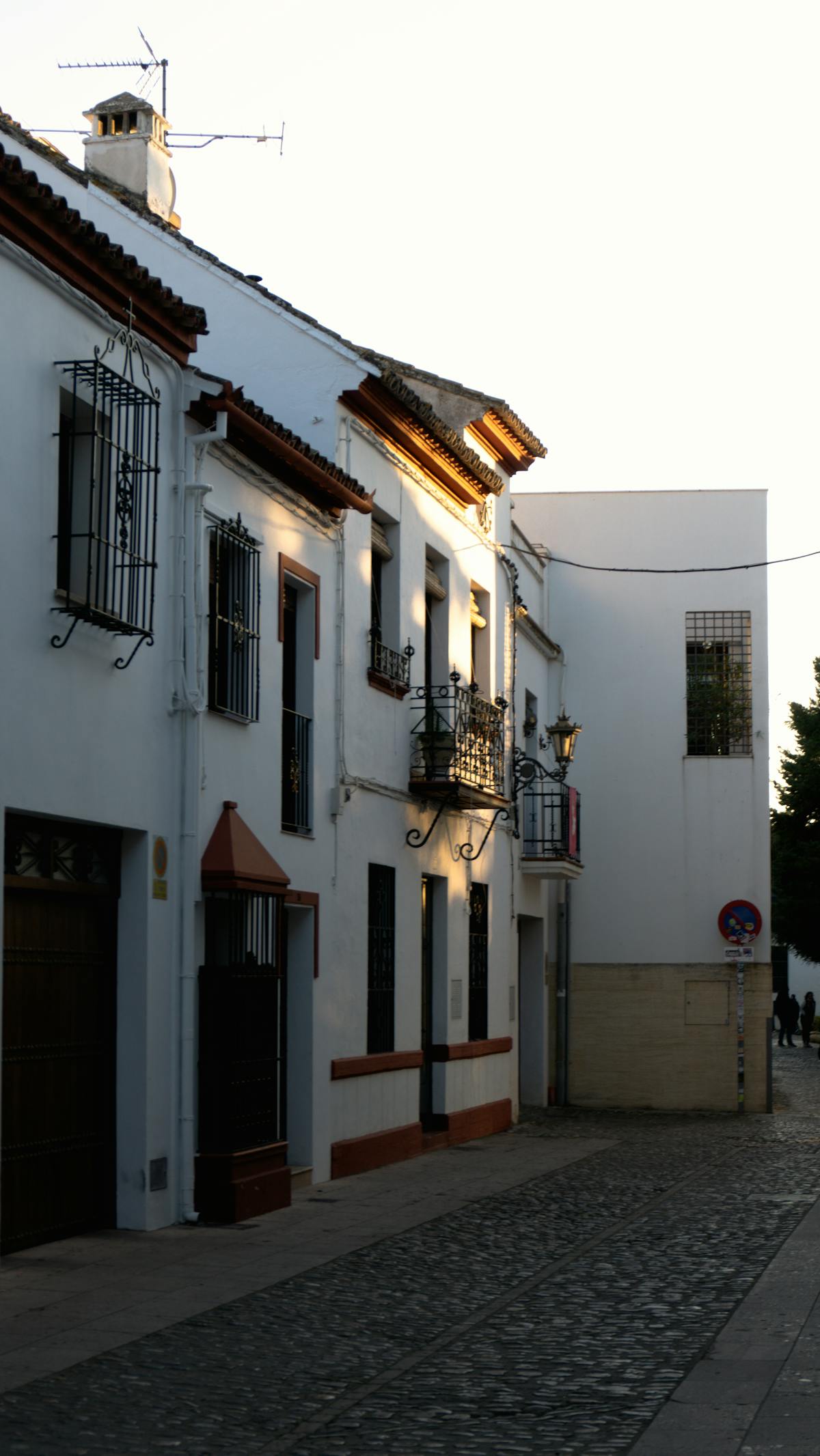 Golden sunset light on cobblestone street and whitewashed buildings in Ronda Andalucia Spain