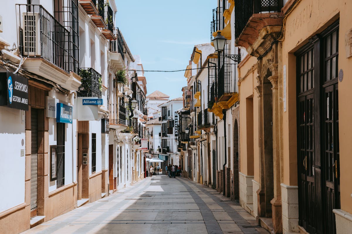 Quiet residential street in Ronda Spain with traditional architecture and flower pots