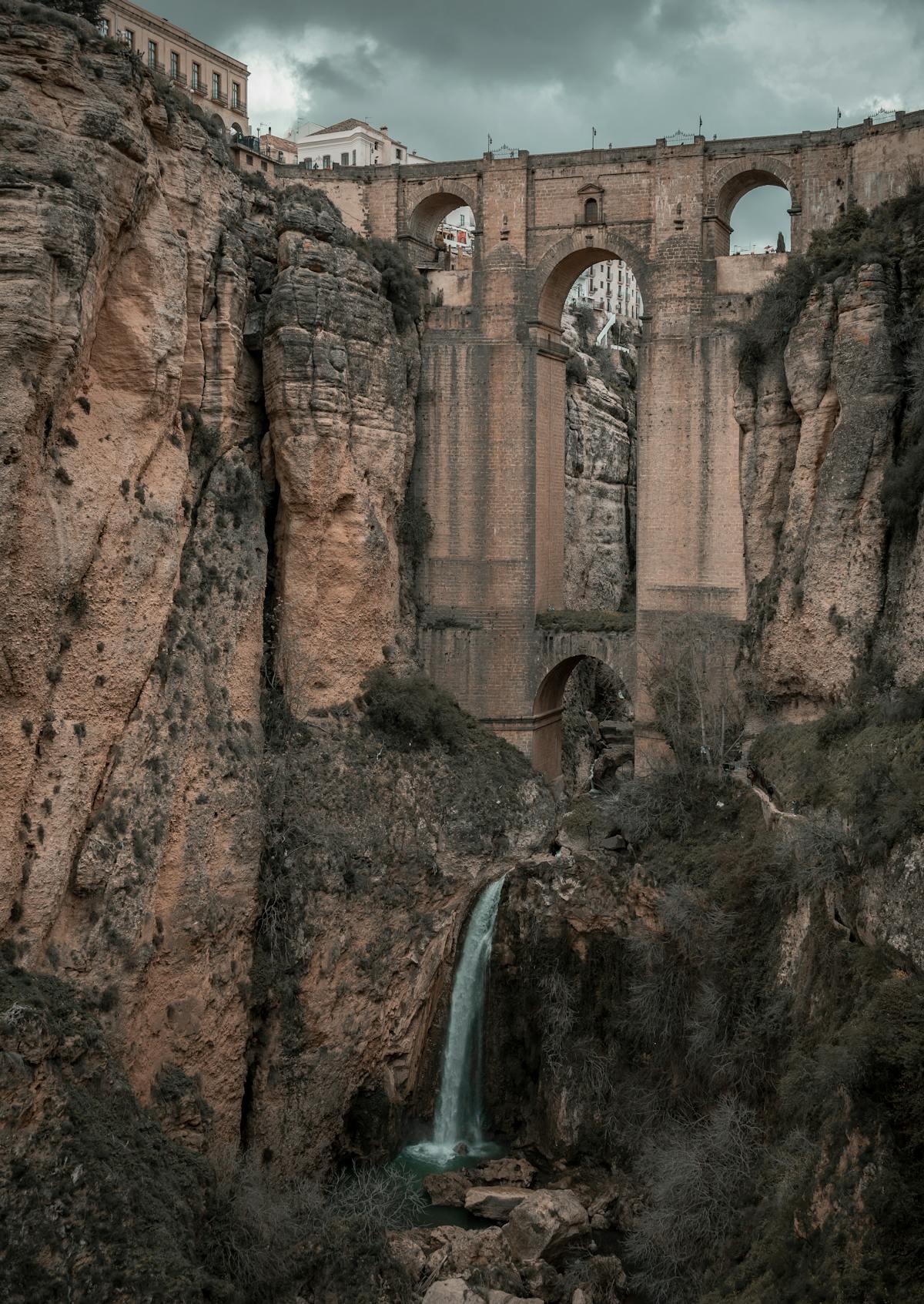 Puente Nuevo arch bridge in Ronda Spain with a waterfall cascading down the gorge walls below