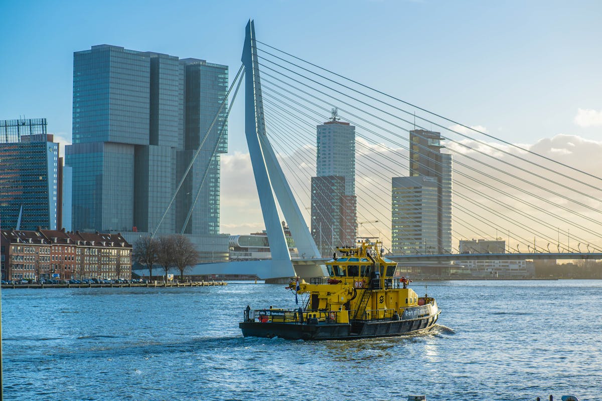 Erasmus Bridge and Rotterdam skyline with a vessel on the Maas River