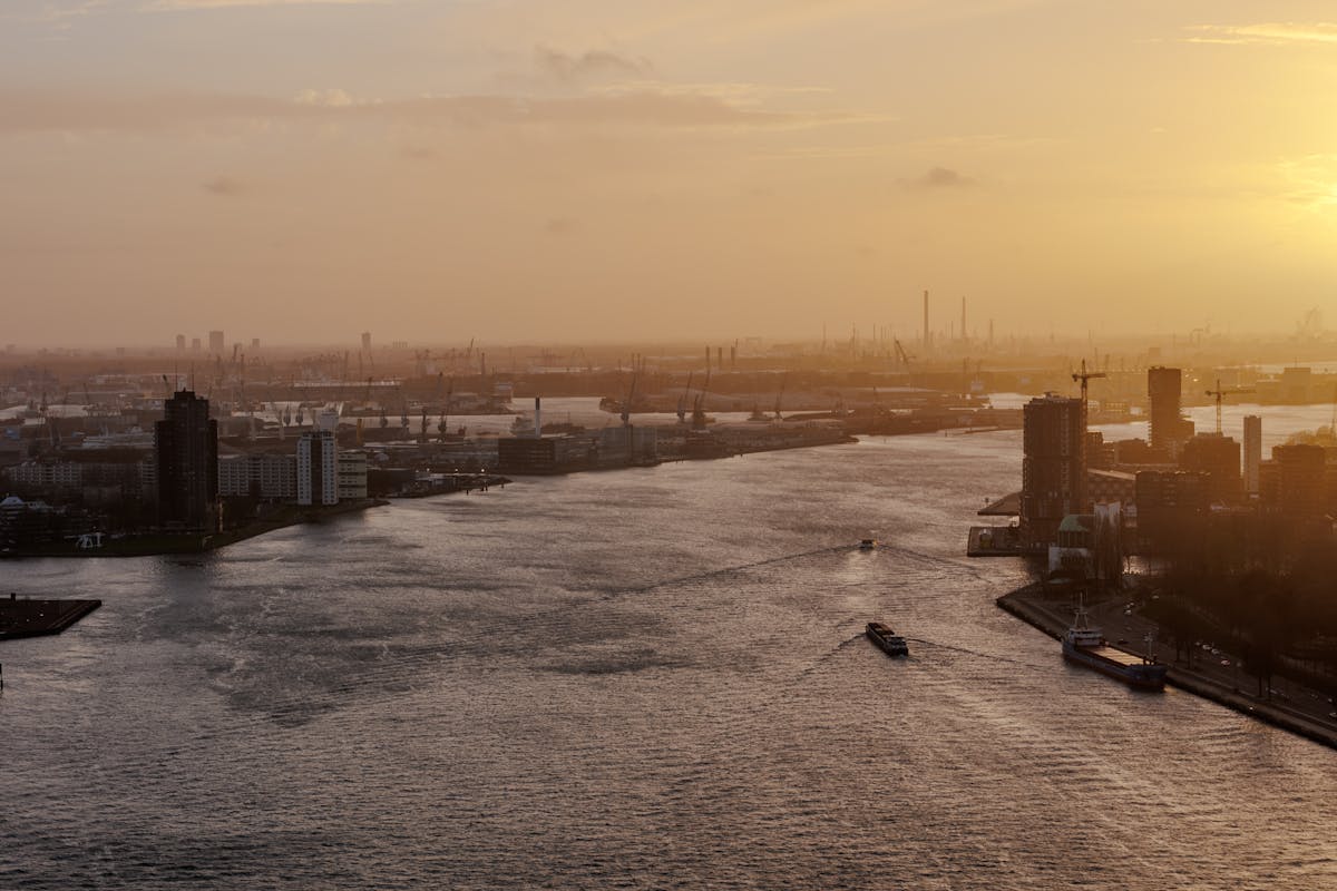 Aerial view of Rotterdam harbor at sunset with city skyline